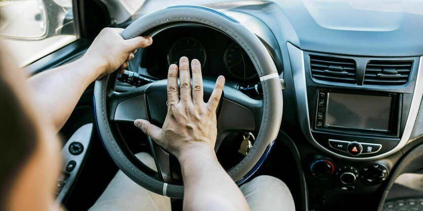 Nahaufnahme Autofahrer drückt auf die Hupe.