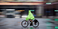Ein Fahrradfahrer fährt im Regen über einer Hauptverkehrsstraße