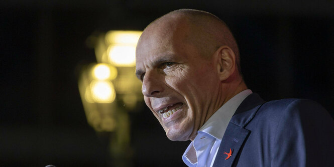 Yanis Varoufakis, griechischer Politiker, mit Lichtschein im Hintergrund.