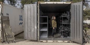 Eine Frau steht in einem Container