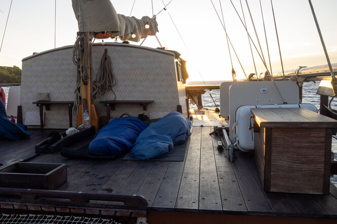 Die Mannschaft verbringt in ihren Schlafsäcken eine Nacht auf Deck.