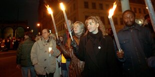 Menschen stehen mit brennenden Fackeln auf der Straße - Lichterkette 1992 in München