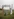 Eine Person döst auf einem Plastikstuhl unter einem improvisierten Tor mit der Aufschrift "Ostsee-Tor" in ans9onsten unverstellter Landschaft