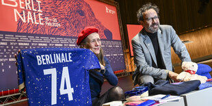 Mariette Rissenbeek und Carlo Chatrian halten ein Triko mit der Aufschrift Berlinale in die Kamera.