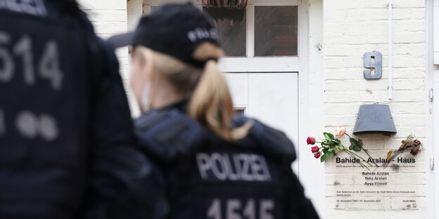 Polizeibeamte stehen in Mölln vor dem Bahide-Arslan-Haus in der Mühlenstraße 9, in dem am 23.11.1992 bei einem Brandanschlag drei Menschen getötet wurden.