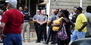 Menschen und Polizisten stehen am Tatort in Dover, Delaware