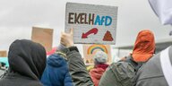 Ein Demonstrant hält ein Plakat mit der Aufschrift "EkelhAfD" in die Höhe