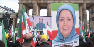 Eine Frau mit Kopftuch auf einem Plakat bei einer Demo vor dem Brandenburger Tor