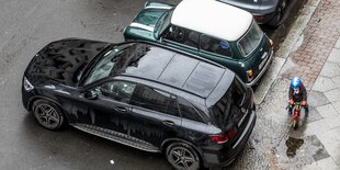 SUV neben Kind auf Parkplatz