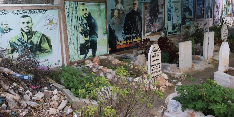 Gräber auf einem Friedhof und Fotos von jungen Männern in Militäruniformen