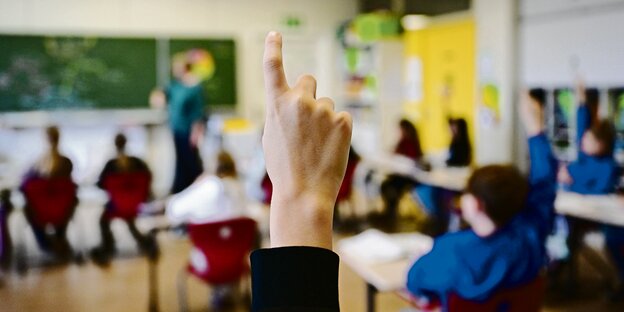 Zwei erhobene Hände in einer Schulklasse