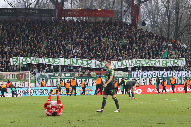 Protest mit Transparent in einem Fußballstadion.