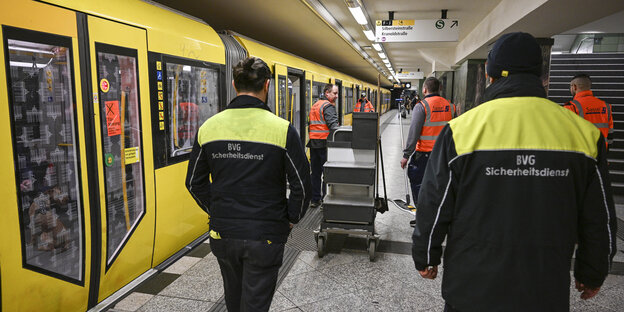 Securityleute und Reinigungskräfte auf einem U-Bahnhof