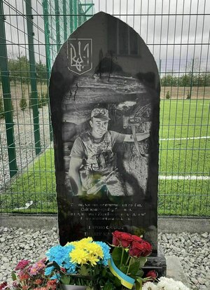 Eine Gedenkstätte für einen gefallenen ukrainischen Soldaten direkt an einem Sportplatz.