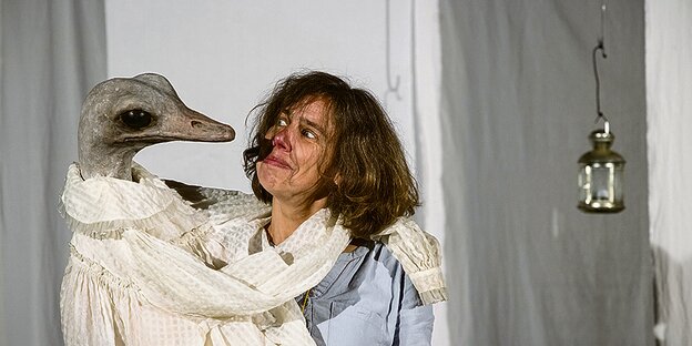 Karin Schmitt hält eine Puppe in Gestalt eines Vogels im Arm