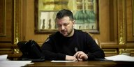 Wolodymyr Selenskyj sitzt an einem Schreibtisch in Kiew und telefoniert