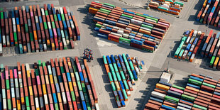 Luftaufnahme von ganz vielen Containern, die in Reih' und Glied auf einem Ladeplatz stehen