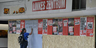 Ein Mann trägt sich vor dem zerstörten Parteibüro der Linken in Oberhausen in eine Unterschriftenliste ein