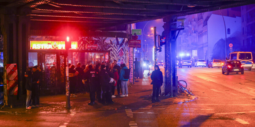 Menschen stehen im Dunkeln vor dem Club Astra-Stube