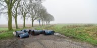 Kanister sind in einer niederländischen Landschaft abgelegt.