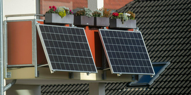 Solarmodule für ein Balkonkraftwerk hängen an einem Balkon.