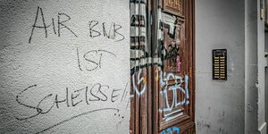 Hauswand mit Graffiti Slogan Parole: AIRBnB ist scheisse