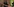 eine Mensch steht vor einer Hauswand und wird von Polizist:innen fotografiert