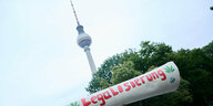 Protesttüte mit Legalisierungsschriftzug bei einer Demo, im Hintergrund der Fernsehturm in Berlin