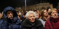 Menschen unterschiedlichsten Alters mit ernsthaften Gesichtern stehen auf einer Demonstration in Budapest