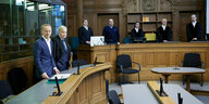 Der angeklagte Arzt und sein Anwalt vor Gericht. im Hintergrund die Richter und die Schöffen