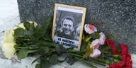 Blumen liegen neben einem Foto von Alexeij Nawalny