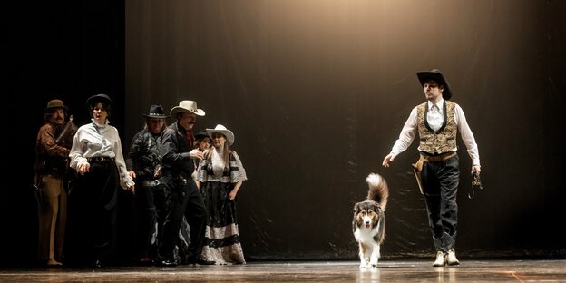 Die SchauspielerInnen mit Westernkleidung und einem Hund auf der Bühne