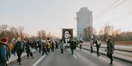 Menschen einer Parade stehen auf einer Hauptstraße in Augsburg und skandieren Parolen