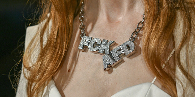 Eine Schauspielerin trägt auf der Berlinale eine große silberne Kette um den Hals: Fuck AFD