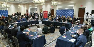 Teilnehmer der CPAC-Konferenz sitzen an Tischen, die im Quadrat angeordnet sind.