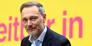 Christian Lindner schaut etwas angeekelt in die Kamera, der Hemdkragen ist geöffnet und die sonnengelbe FDP-Farbe leuchtet im Hintergrund