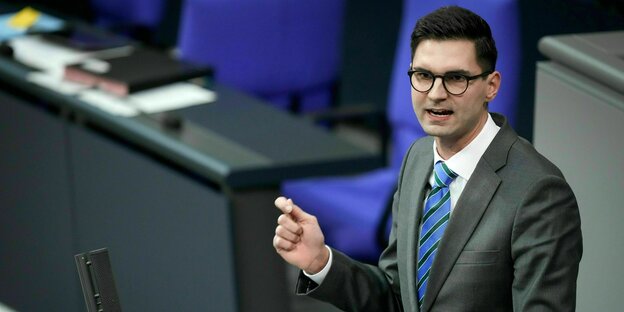 Sepp Müller steht im Anzug und hübscher blauer Krawatte im Bundestag und darf eine Rede halten