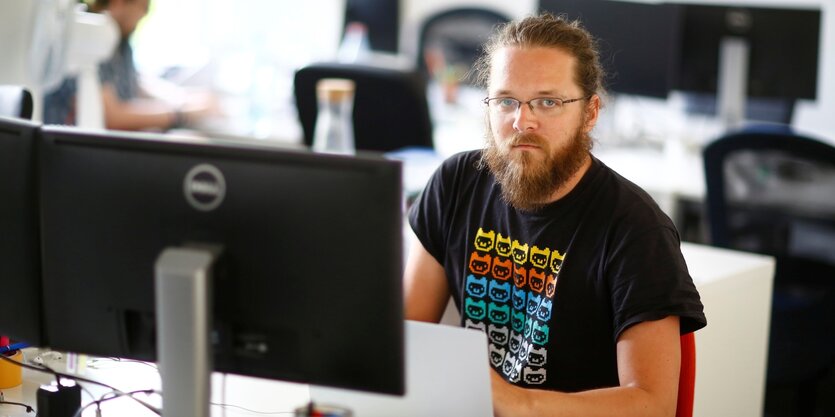 Der Journalist Arne Semsrott sitzt an einem Computer und schaut in die Kamera