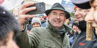 Ein gut gelaunter Hubert Aiwanger macht ein Selfie mit protestierenden Bauern