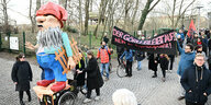 Der selbst gebastelte Gartenzwerg mit roter Zipfelmütze wird von Demonstrierenden auf einem Wagen durch den Görlitzer Park geschoben. Sie protestieren gegen den geplanten Zaunbau rund um den Görli.