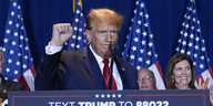 Donald Trump ballt an einem Rednerpult vor US-Fahnen die Faust