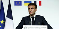 Emmanuel Macron mit ernstem Blick hinter einem Rednerpult