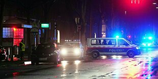 Ein Polizeiauto steht quer auf einer Straße im Dunkeln