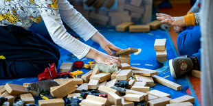 Zwei Kinder spielen in einer Kita mit Klötzchen