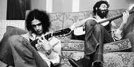 Jards Macalé auf einem Sofa in London mit der Gitarre, davor sitzt Caetano Veloso, ebenfalls mit Gitarre (das Foto ist von 1970)