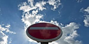 Ein Schild "Durchfahrt verboten" vor Wolkenhimmel