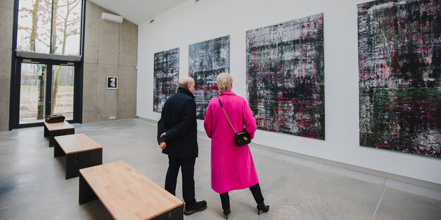 Zwei Personen stehen vor froßformativen modernen Gemälden