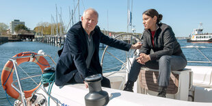 Ein Mann und eine Frau sitzen auf einem Segelboot.