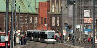 Bus, Bahn, und Fahrgäste an der Haltestelle Domsheide in Bremen; im Hintergrund ist das Konzerthaus Glocke zu sehen