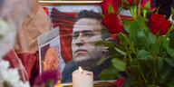 An einer behelfsmäßigen Gedenkstätte gegenüber der russischen Botschaft in London stehen Blumen, Kerzen, und Karten um ein gerahmtes Foto von Alexej Nawalny.